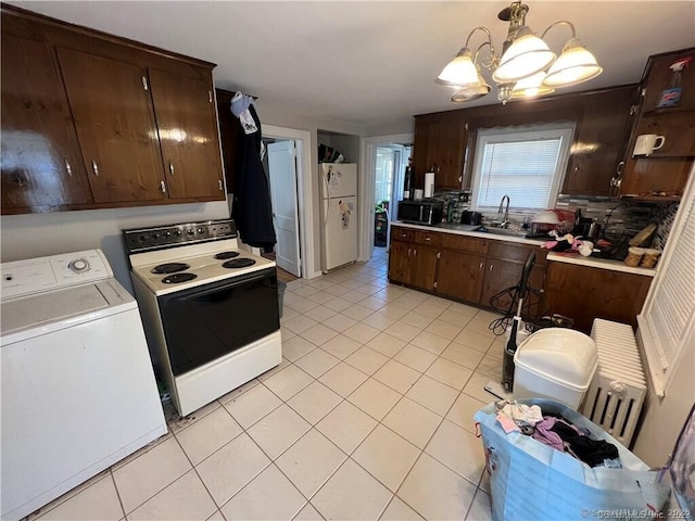 kitchen featuring backsplash, light countertops, white appliances, washer / clothes dryer, and a sink