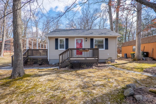 view of front facade featuring a deck and a front lawn