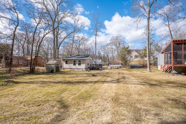 view of yard with a shed, an outdoor structure, and a sunroom