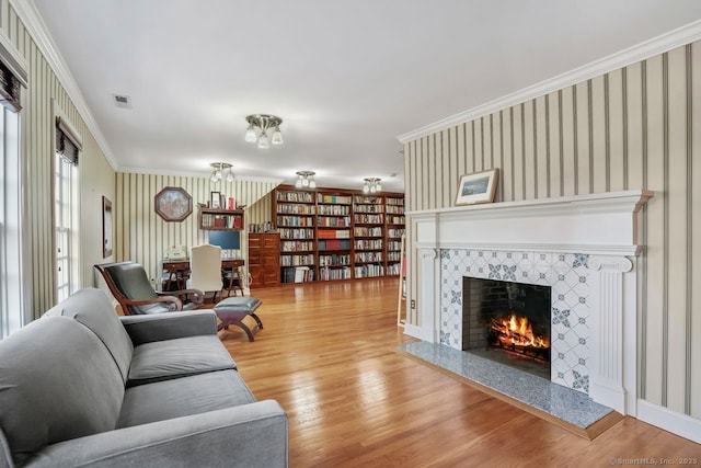 35 Grace View Dr, Easton, CT 06612 - living area with wallpapered walls, a tiled fireplace, wood finished floors, and crown molding