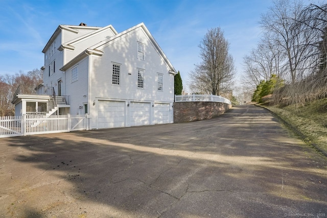 35 Grace View Dr, Easton, CT 06612 - view of side of property featuring a garage, driveway, a gate, and a chimney