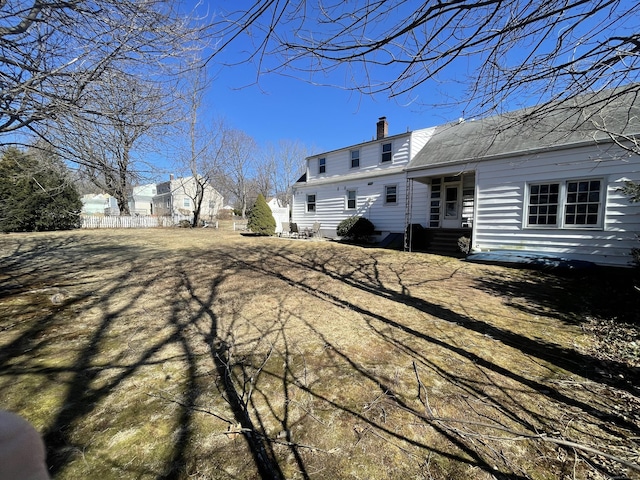 rear view of house with entry steps and a chimney