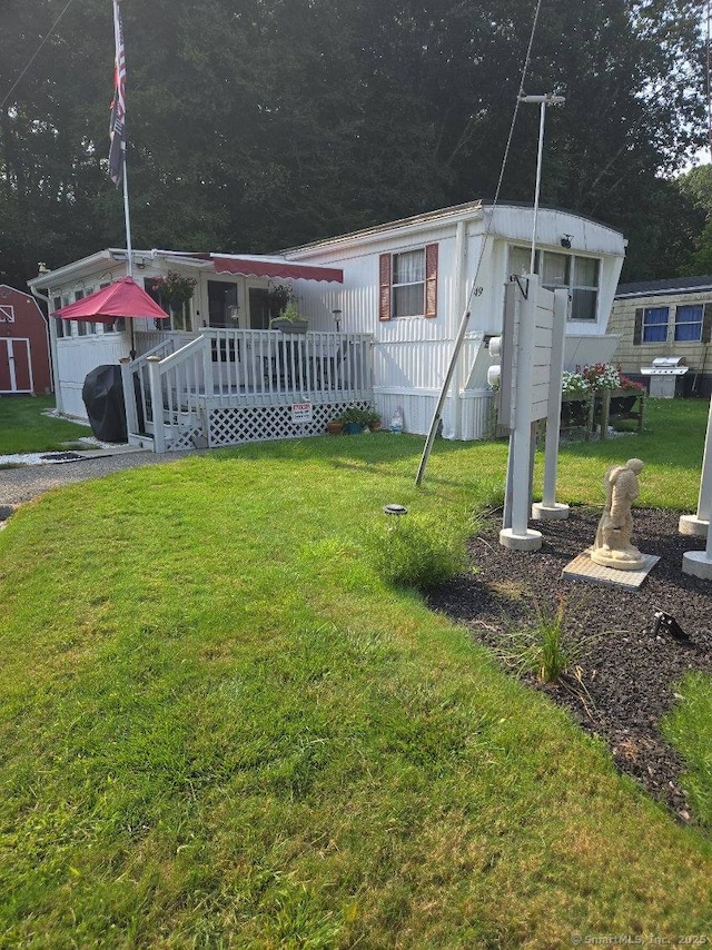 manufactured / mobile home with a deck and a front yard