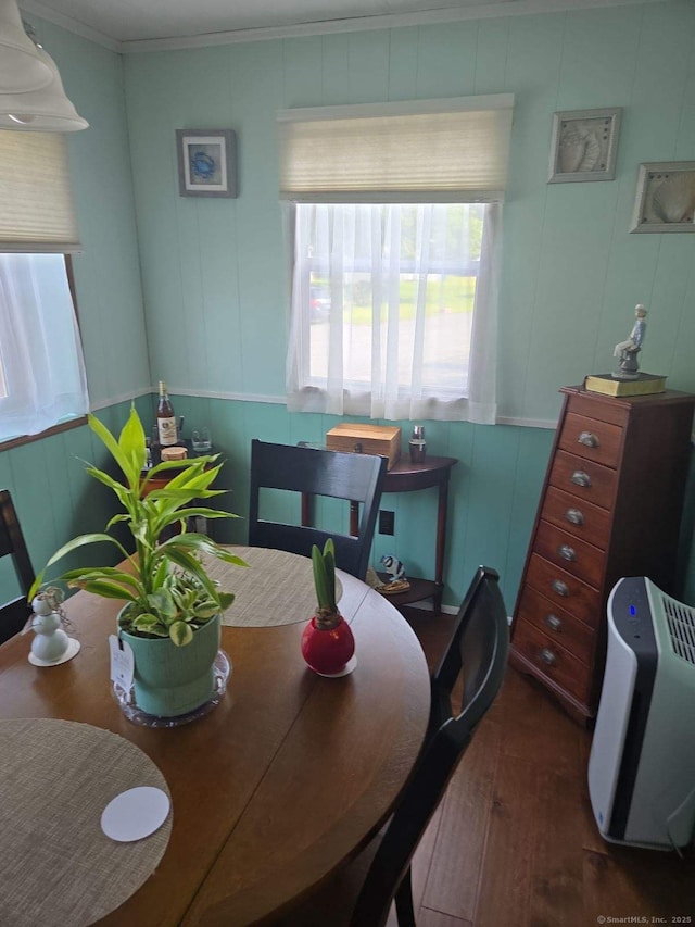 dining space with crown molding and wood finished floors