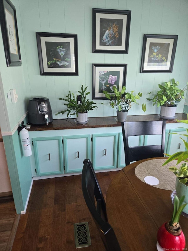 room details featuring wood finished floors, visible vents, and a fire extinguisher