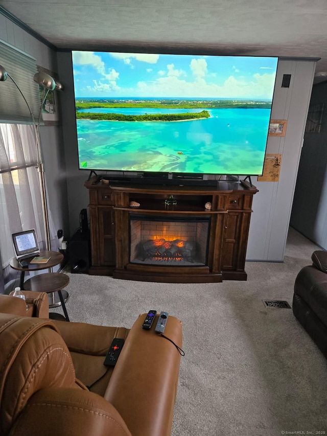 living area featuring visible vents, a warm lit fireplace, and light carpet