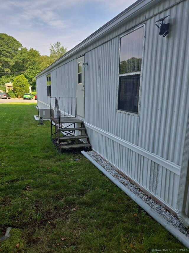 view of side of property with a yard and entry steps