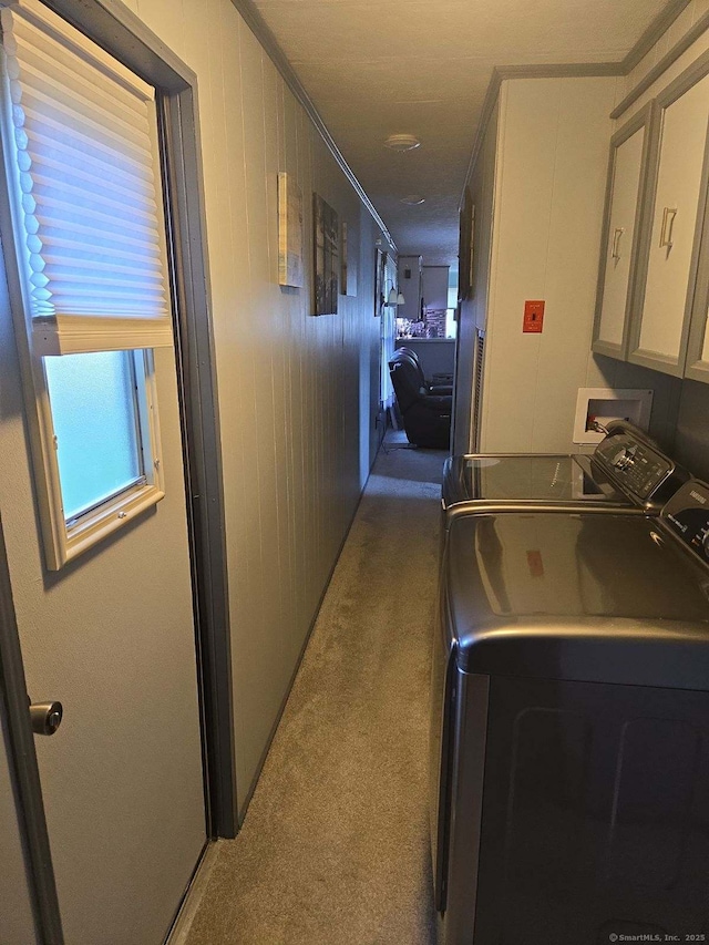 hallway with washer and dryer, ornamental molding, and carpet floors