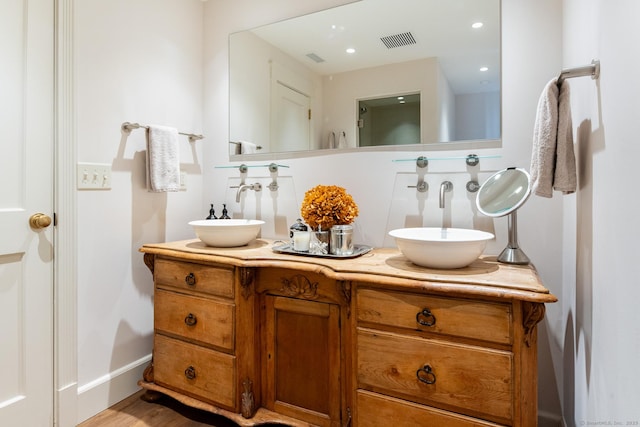 full bath featuring a sink, visible vents, recessed lighting, and double vanity