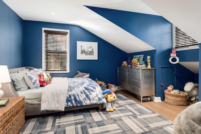 bedroom with lofted ceiling and wood finished floors