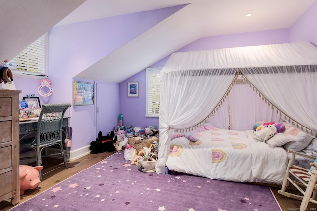 bedroom with multiple windows, lofted ceiling, baseboards, and wood finished floors