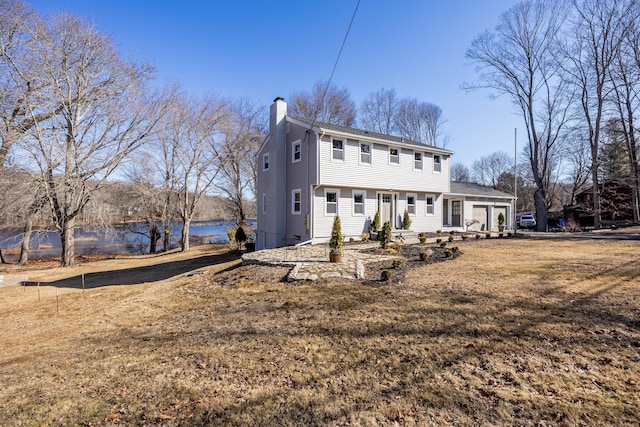 view of front of home featuring an attached garage and a chimney