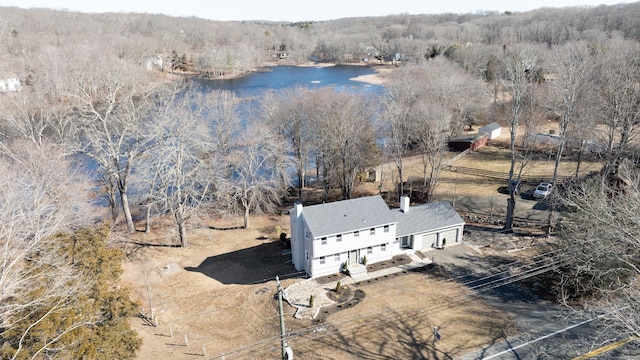 birds eye view of property featuring a wooded view and a water view