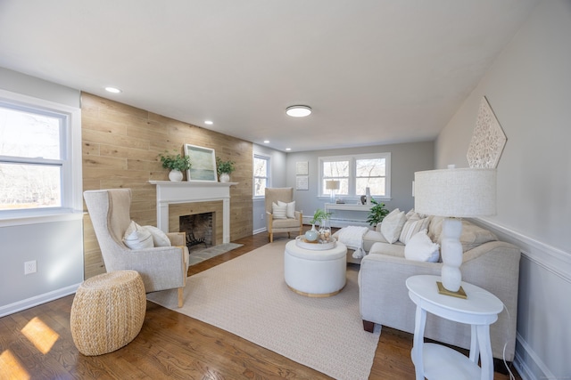 living room featuring a fireplace with flush hearth, recessed lighting, and wood finished floors