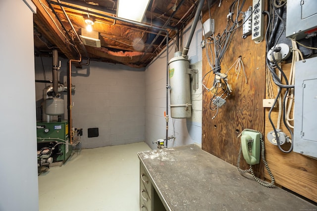 unfinished below grade area with a heating unit, electric panel, and concrete block wall