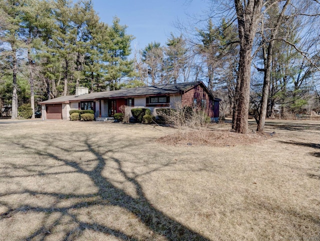 view of front of home featuring a chimney and an attached garage