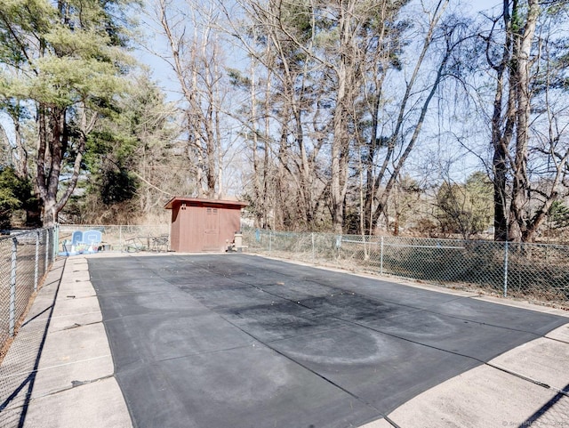 view of pool featuring an outdoor structure, a shed, and fence