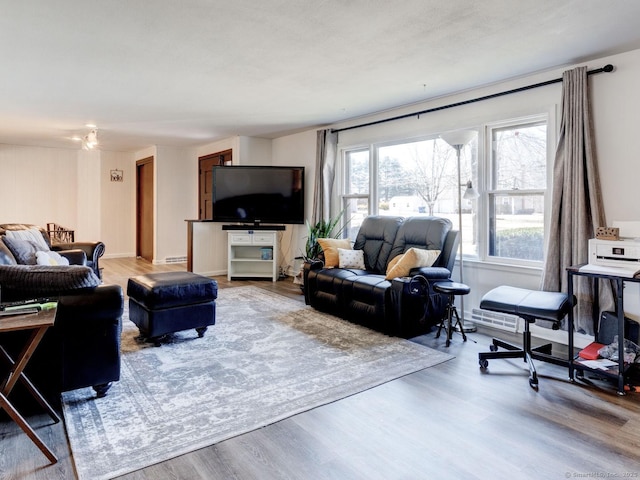 living room with a baseboard heating unit and wood finished floors