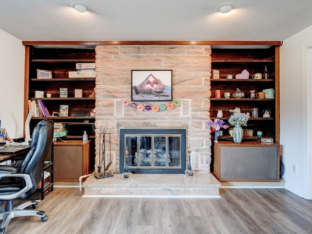 office space featuring a fireplace and wood finished floors