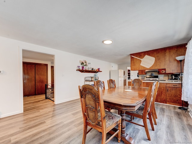 dining area featuring baseboards and light wood-style floors