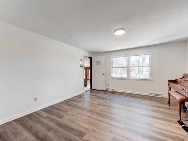 interior space with visible vents, baseboards, and wood finished floors