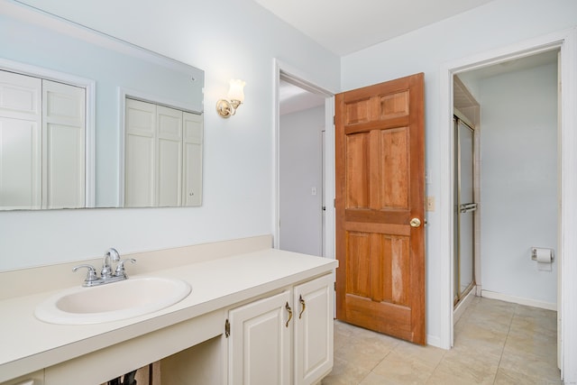 bathroom with tile patterned floors, a shower stall, vanity, and baseboards