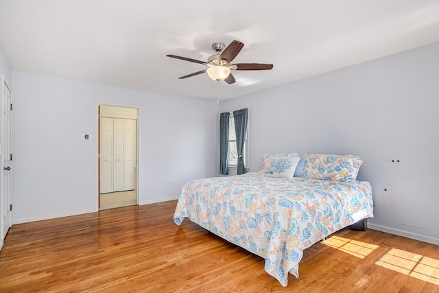 bedroom featuring light wood-style flooring, a ceiling fan, and baseboards