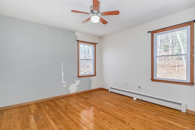 unfurnished room featuring light wood-type flooring, baseboards, baseboard heating, and ceiling fan