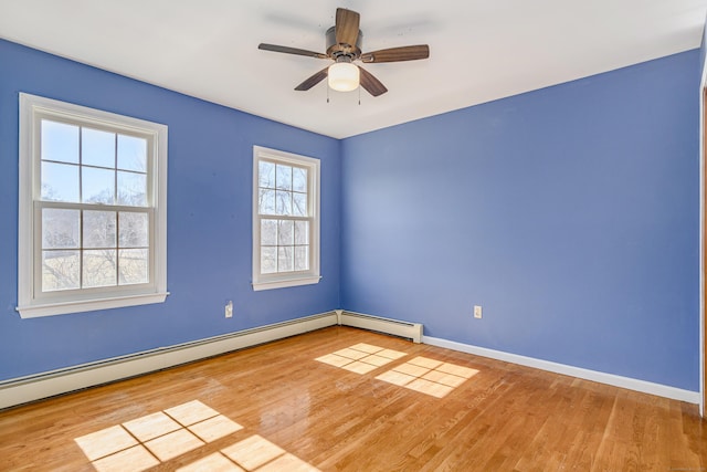 spare room featuring ceiling fan, baseboards, baseboard heating, and wood finished floors