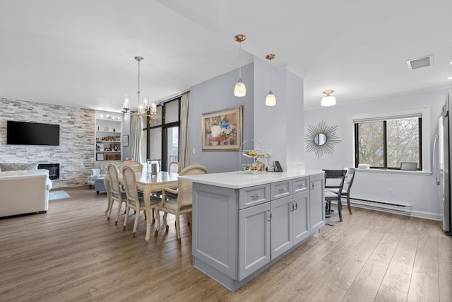 kitchen with visible vents, gray cabinetry, freestanding refrigerator, light wood-style floors, and a baseboard radiator