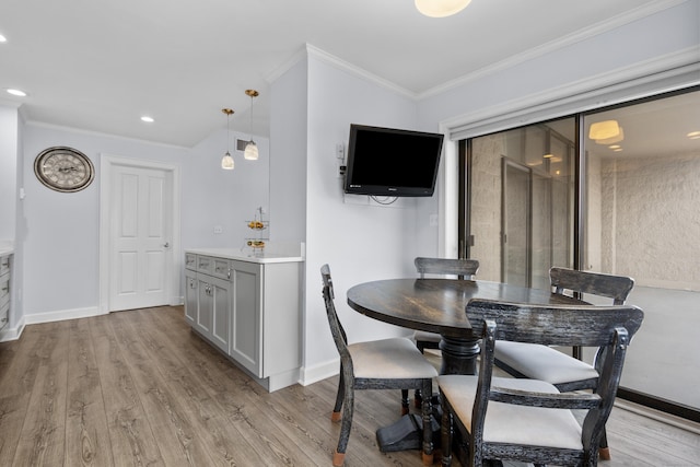 dining space featuring crown molding, light wood-style flooring, recessed lighting, and baseboards