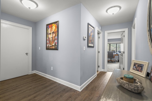 corridor with dark wood-style floors and baseboards