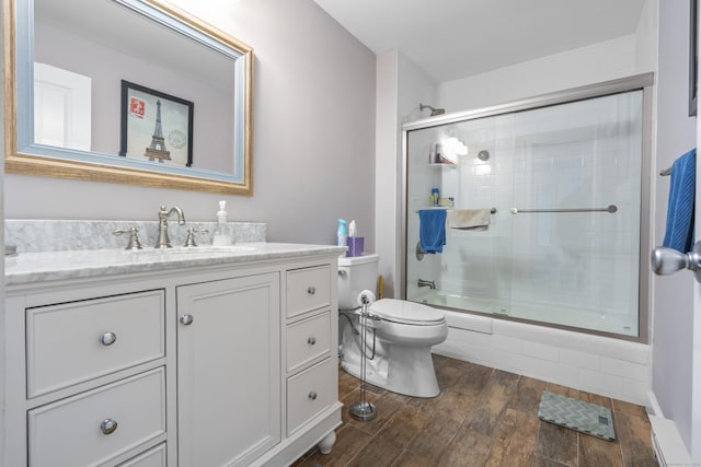 bathroom featuring vanity, toilet, wood finished floors, and combined bath / shower with glass door