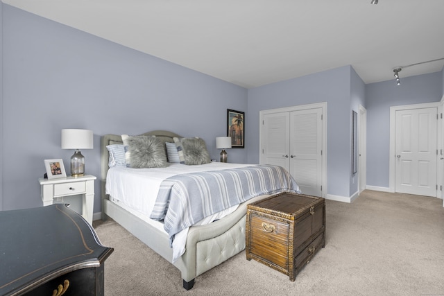 carpeted bedroom featuring baseboards and a closet