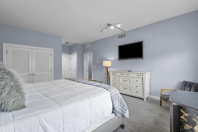 carpeted bedroom with visible vents, multiple closets, and baseboards