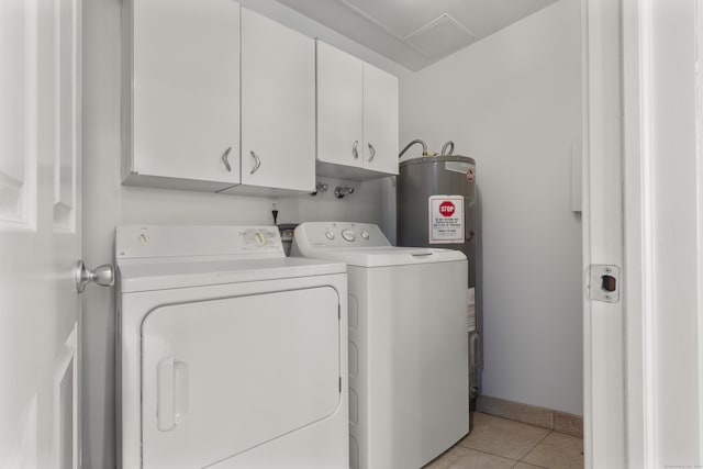 clothes washing area featuring light tile patterned floors, cabinet space, baseboards, and washing machine and clothes dryer