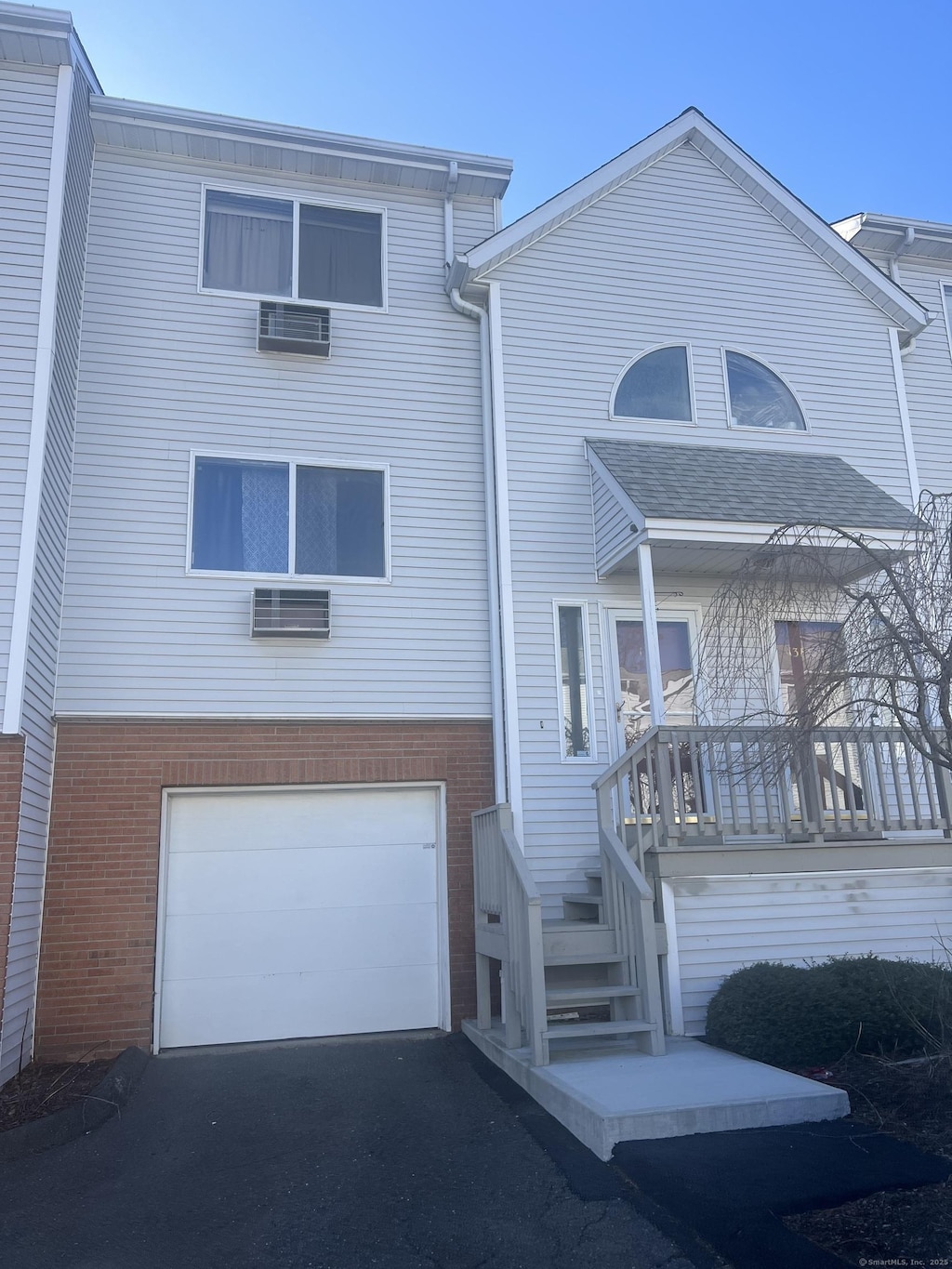 view of front of house with brick siding, driveway, and a garage