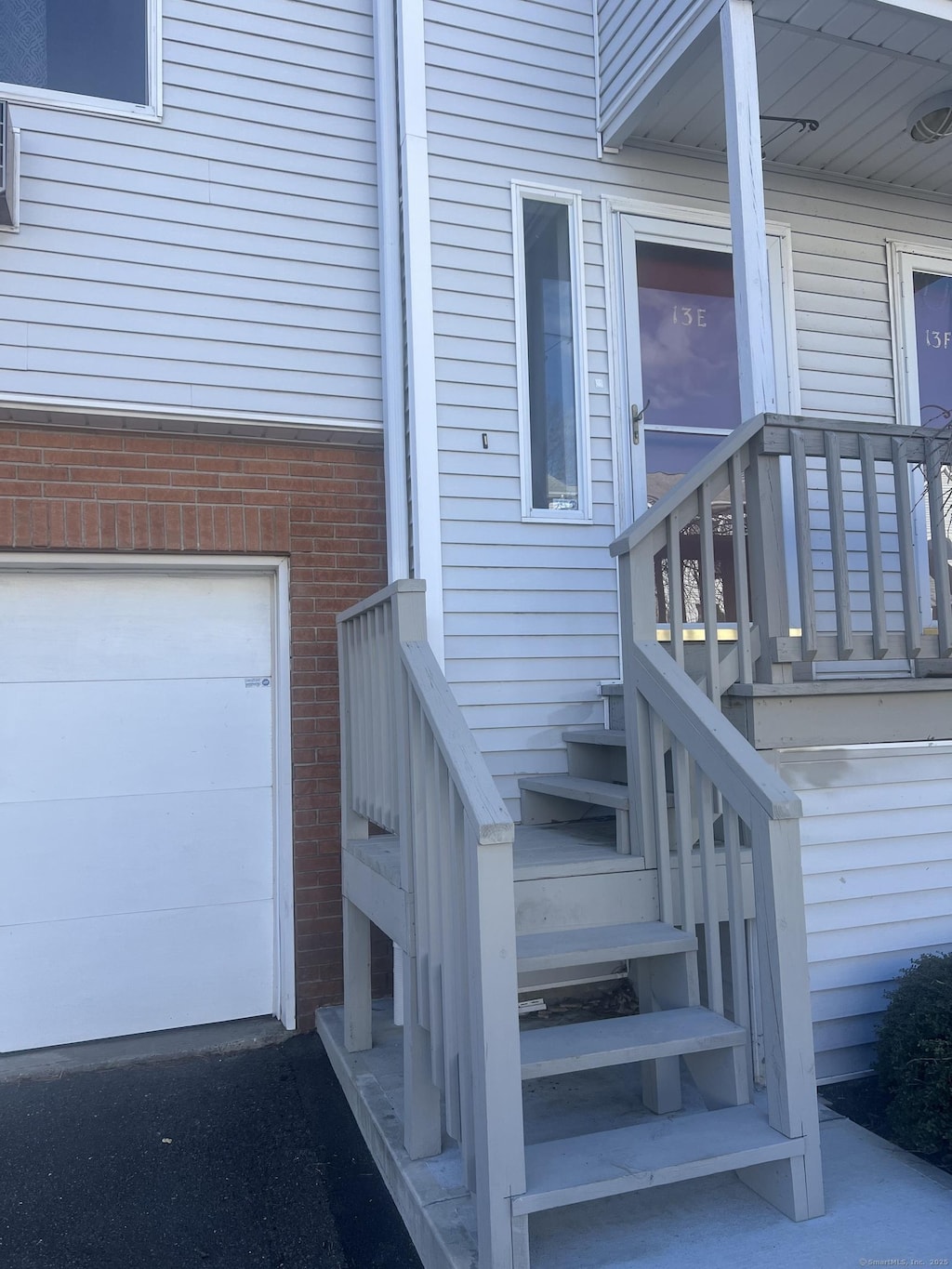 view of exterior entry featuring brick siding and a garage