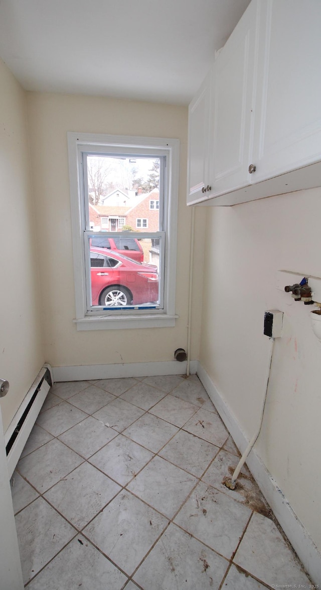 washroom featuring a baseboard heating unit, cabinet space, and baseboards