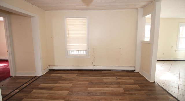 empty room with a baseboard heating unit, wood ceiling, wood finished floors, and a wealth of natural light