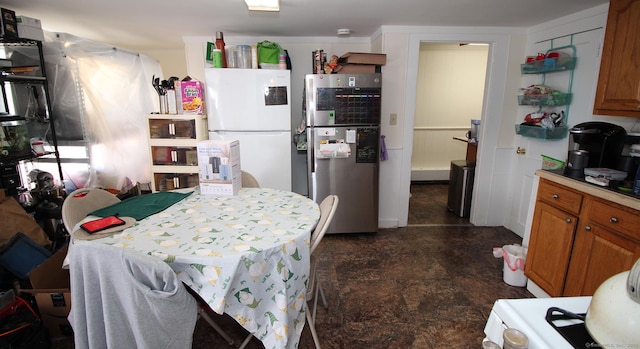 kitchen featuring brown cabinets, light countertops, and freestanding refrigerator