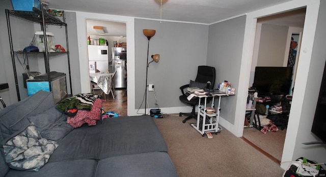 carpeted bedroom with baseboards and freestanding refrigerator