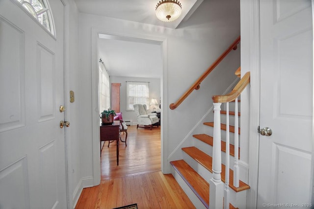 entrance foyer featuring light wood-type flooring, baseboards, and stairs