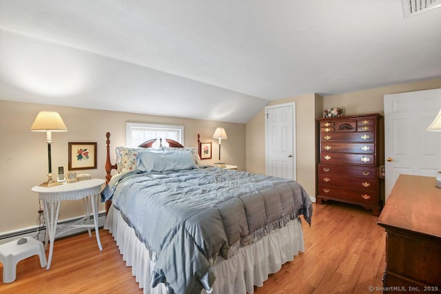 bedroom featuring visible vents, light wood-style flooring, baseboard heating, and lofted ceiling