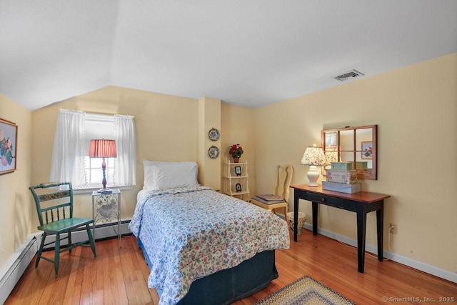 bedroom with visible vents, baseboards, vaulted ceiling, and hardwood / wood-style flooring