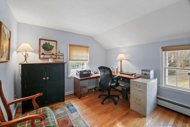 office featuring vaulted ceiling, baseboards, light wood-type flooring, and a baseboard radiator