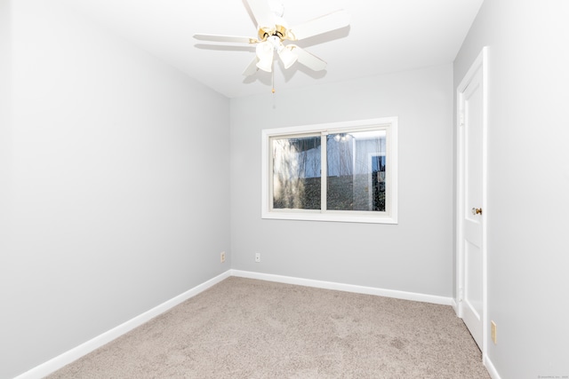 empty room featuring carpet flooring, baseboards, and ceiling fan