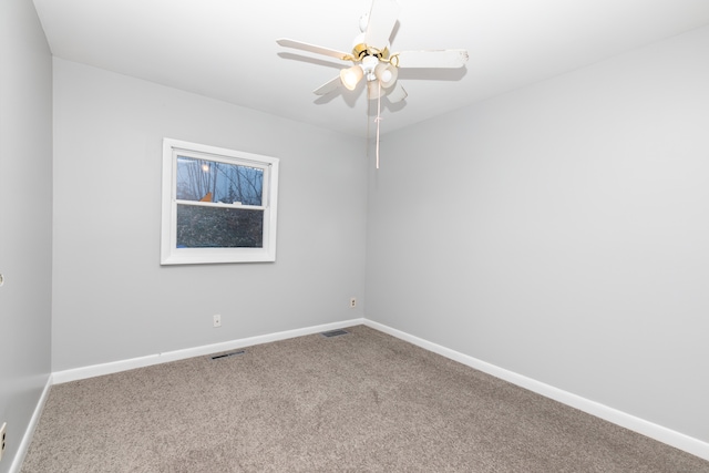 carpeted empty room with baseboards, visible vents, and ceiling fan