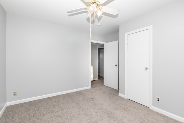 unfurnished bedroom featuring a ceiling fan, baseboards, and light carpet