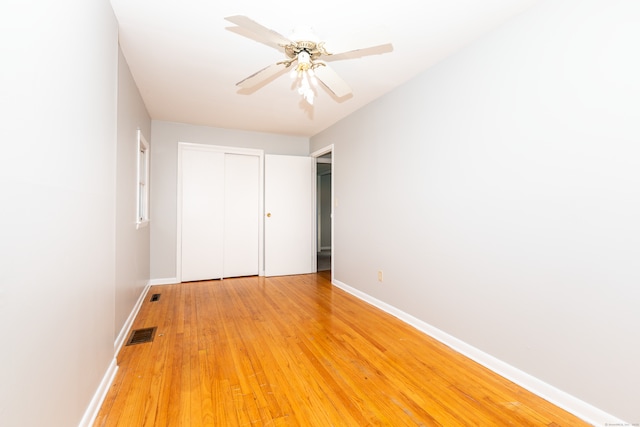 unfurnished bedroom featuring a closet, visible vents, light wood-type flooring, and baseboards